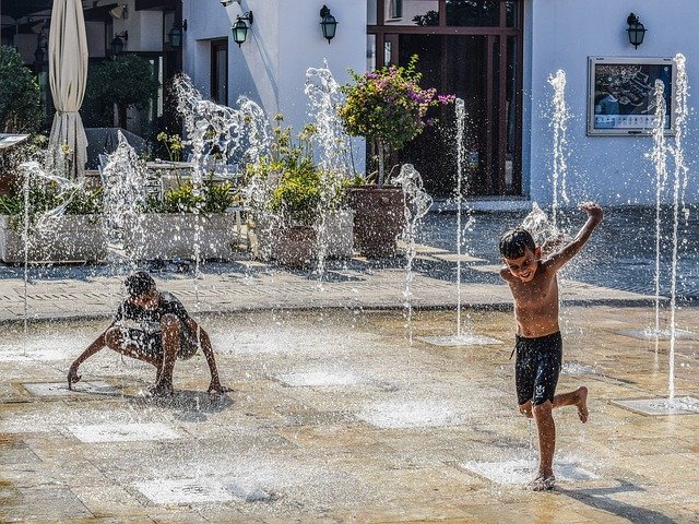 kids playing in water fountain